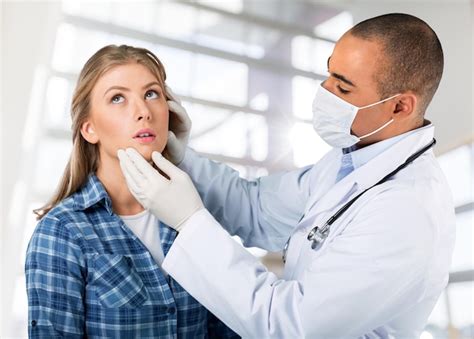 Fotografía de un médico examinando la cavidad oral de un paciente