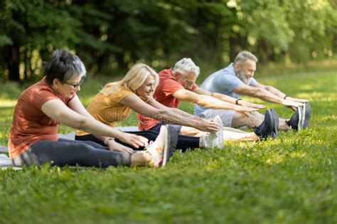 Grupo de adultos mayores haciendo ejercicios aeróbicos ligeros al aire libre