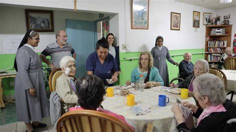 Miembros del personal del Hogar de Ancianos María de la Luz interactuando amablemente con residentes.