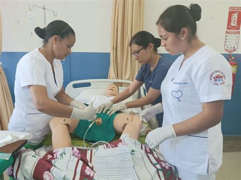 Imagen de estudiantes de enfermería realizando una simulación clínica con un paciente ficticio o un modelo.