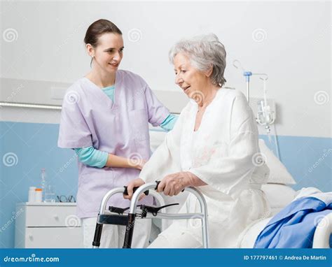 Enfermera apoyando a un paciente de edad avanzada en cama