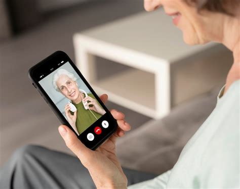 Foto de una persona mayor haciendo una videollamada con alegría