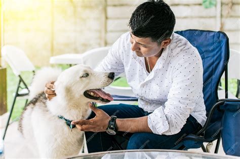 Foto de una persona mayor acariciando a su perro tranquilamente en casa