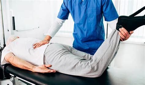 Fotografía de un kinesiólogo interactuando con un paciente durante una sesión de terapia