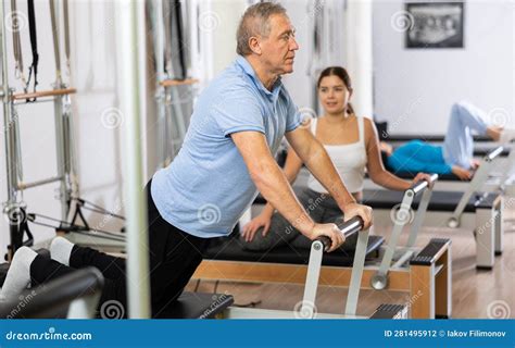 Ancianos realizando ejercicios de pilates en grupo con un instructor