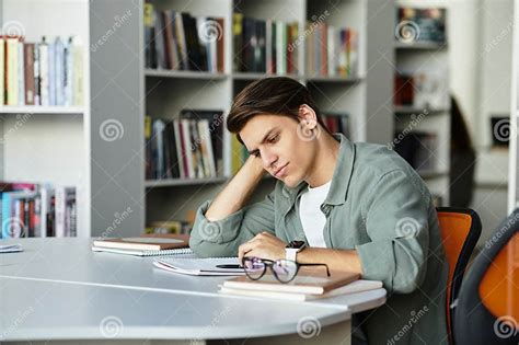 Foto de un adulto mayor concentrado estudiando en una biblioteca o con materiales educativos