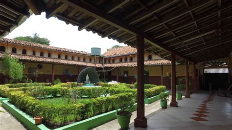 Fotografía del Asilo San Antonio, mostrando la fachada del edificio con áreas verdes y personas mayores interactuando.