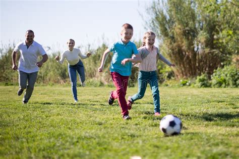 Foto temática: Campo de fútbol con niños jugando en un barrio vulnerable de Chile al atardecer