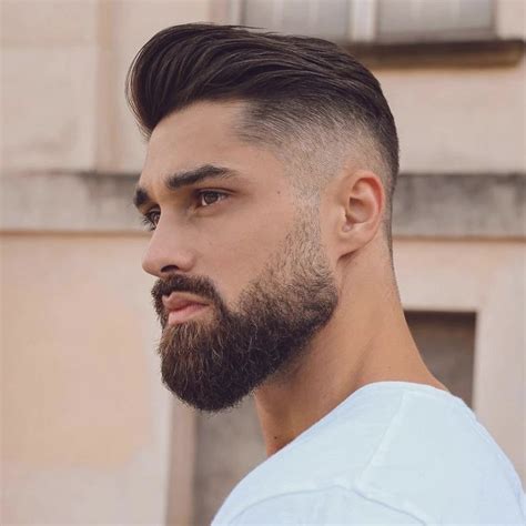 Hombre con barba corta, lados afeitados y volumen en la parte superior