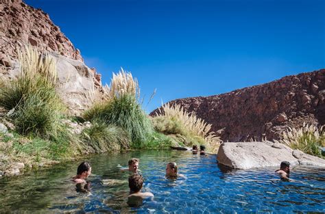 Foto panorámica de las Termas de Puritama en un cañón, destacando sus pozas de agua templada y el entorno natural.