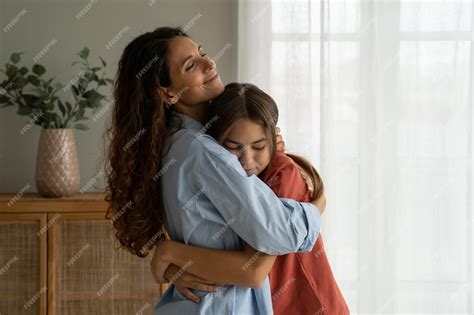Foto de una madre abrazando a su hija adolescente con discapacidad, mostrando afecto y esperanza