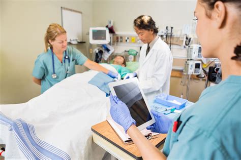 Foto de estudiantes de medicina o enfermería interactuando con un paciente mayor en un entorno de cuidado