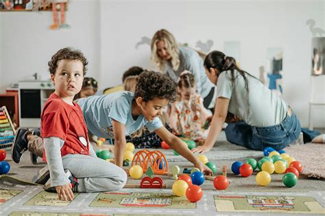 Foto de niños pequeños interactuando con materiales educativos inclusivos.