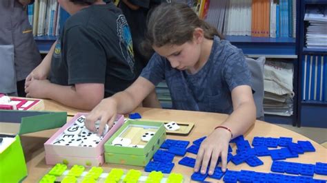 Niño con discapacidad visual utilizando materiales didácticos adaptados en un entorno escolar inclusivo