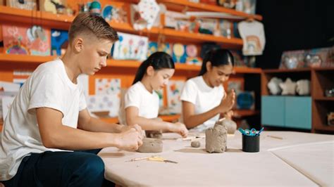 Estudiante con discapacidad intelectual trabajando con arcilla en un taller de arteterapia, mostrando calma y concentración.