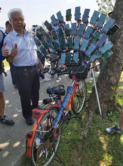 Fotografía de Chen San-yuan sobre su bicicleta equipada con múltiples dispositivos móviles para jugar Pokémon GO.