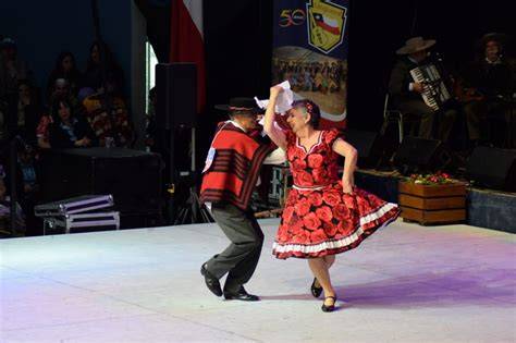 Fotografía de parejas de adultos mayores bailando cueca en un escenario tradicional.