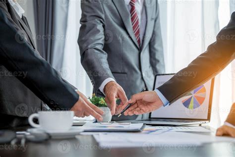 Fotografía de una persona en una reunión de negocios, llevándose la mano a la boca mientras escucha atentamente.