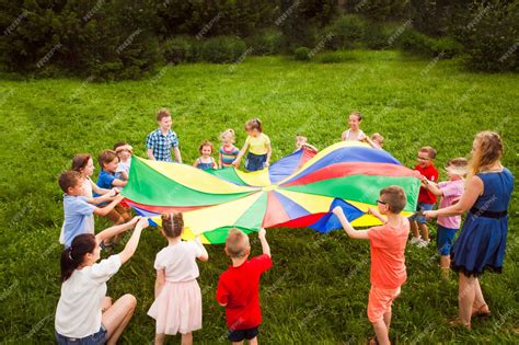 Niños jugando con un paracaídas multicolor, fomentando la interacción.