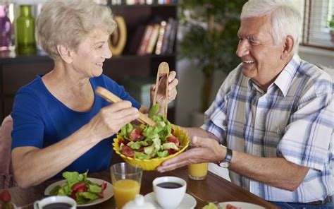 imagen de un adulto mayor disfrutando de un plato de comida equilibrada con proteínas y verduras