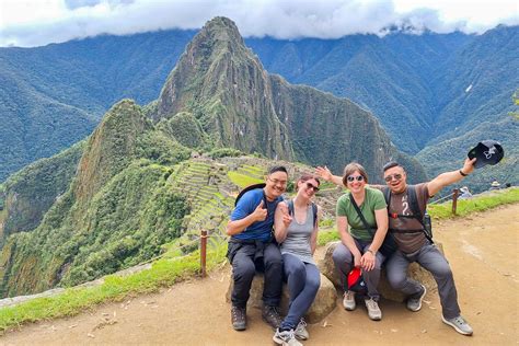 Fotografía panorámica de la ciudadela de Machu Picchu con turistas disfrutando del paisaje