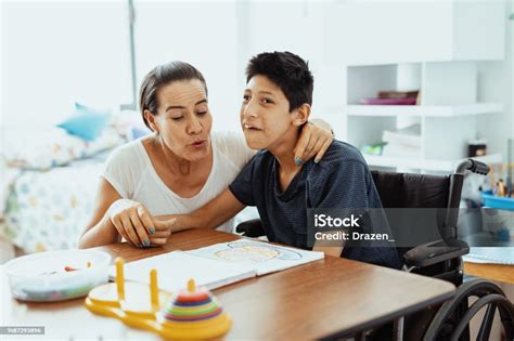 Foto de niños con discapacidad haciendo manualidades o cocinando con adultos.