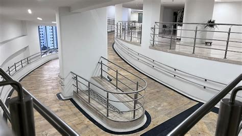 Interior de un hospital con pasillos amplios, rampas suaves y señalización clara para personas con discapacidad