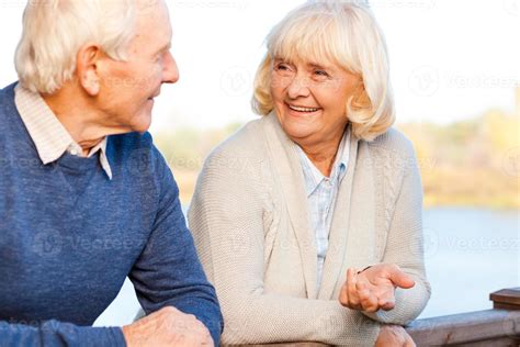 Pareja de ancianos conversando en un parque, simbolizando la importancia de la comunicación.