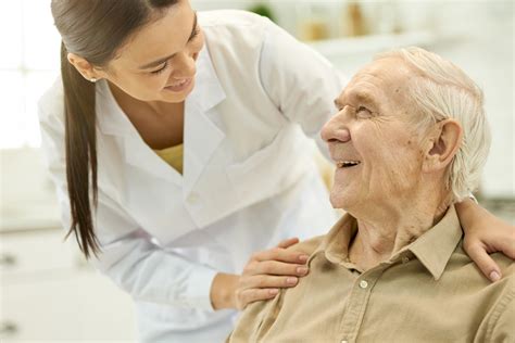 Ilustración: Adulto mayor interactuando con personal de salud en un CESFAM, destacando la importancia de la comunicación