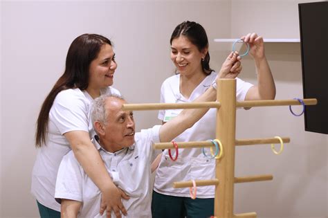 Foto de persona mayor realizando ejercicios de terapia ocupacional con un profesional