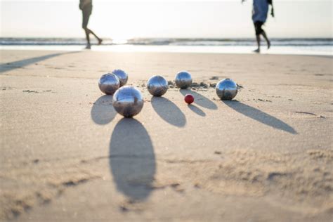 Grupo de adultos mayores jugando petanca en la playa
