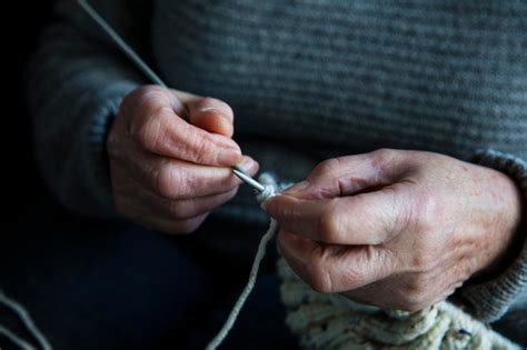 Primer plano de las manos de una persona mayor explorando un cubo sensorial