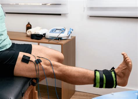 Fotografía: Fisioterapeuta aplicando estimulación eléctrica muscular a paciente postrado