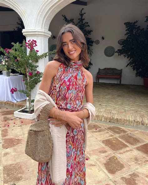 Mujer curvy de edad madura vistiendo un vestido boho chic con estampado floral y accesorios naturales, sonriendo en un parque