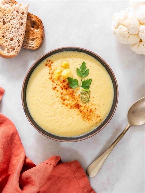 Fotografía: Sopa de coliflor cremosa servida en un tazón con un chorrito de aceite de oliva y tomillo fresco