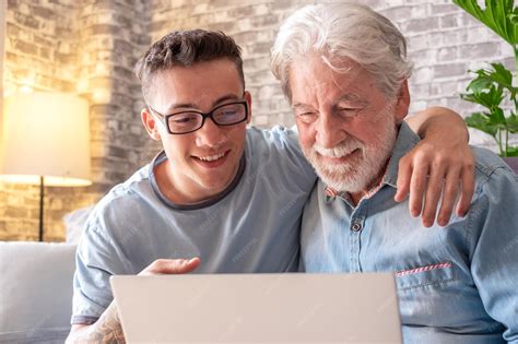 Foto de un adulto mayor sonriendo mientras usa una tablet o un ordenador portátil