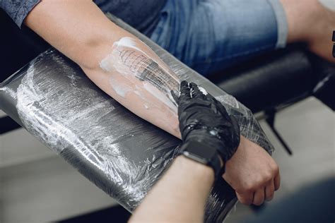 Foto de una persona mayor mostrando un tatuaje recién hecho o curado