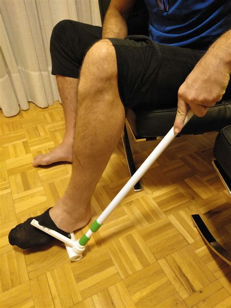 Persona mayor usando un calzador de calcetines