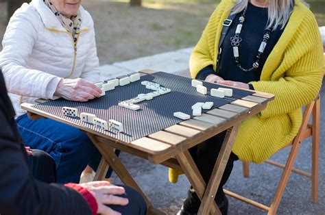 Foto de adultos mayores jugando juegos de mesa y resolviendo crucigramas en un taller