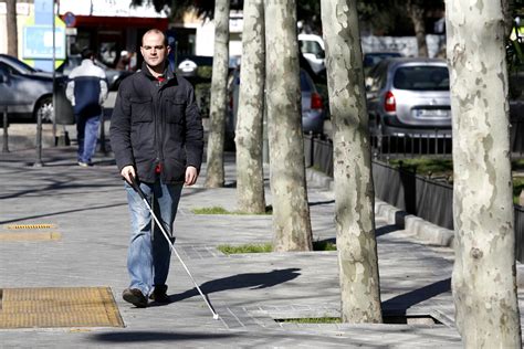 Símbolo de persona caminando con bastón para discapacidad visual
