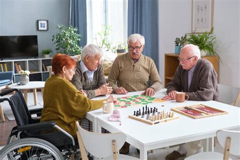Fotografía de un grupo de adultos mayores jugando un juego de mesa o resolviendo un sudoku.