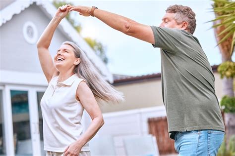 Pareja mayor riendo y bailando juntos, mostrando alegría y vitalidad