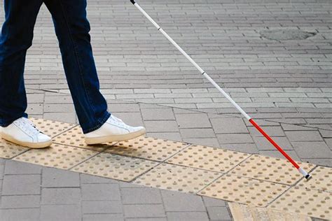 Esquema de un entorno accesible para personas con discapacidad visual, mostrando señalización táctil y auditiva