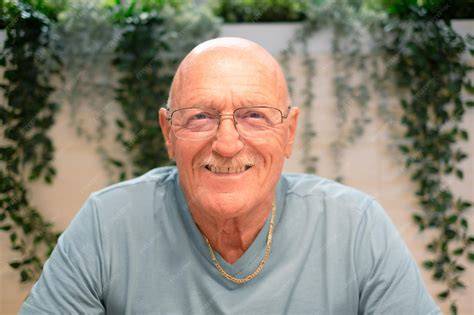 Fotografía de un adulto mayor sonriendo mientras usa gafas, dando una sensación de bienestar visual