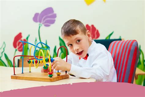 Niño con discapacidad motriz jugando felizmente con un juguete adaptado