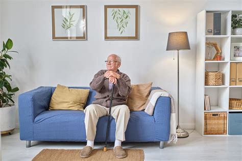 Imagen de un adulto mayor recibiendo apoyo en casa, combinando la presencia humana con dispositivos de asistencia