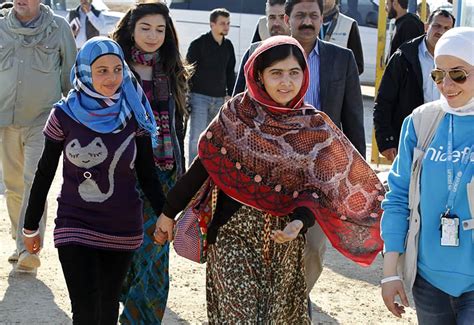 Malala Yousafzai y la refugiada siria Muzoon Rakan caminando en un centro de UNICEF antes de una conferencia de prensa en el campo de refugiados de Zaatri, Jordania.