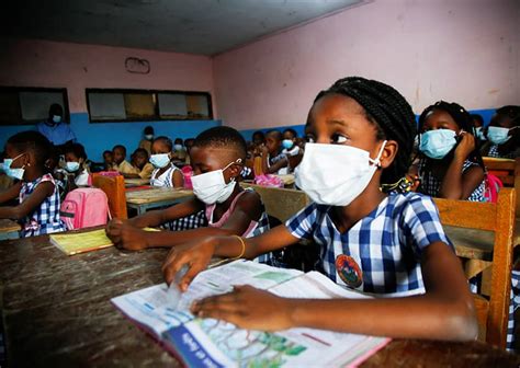 Estudiantes con mascarillas protectoras en un aula en Costa de Marfil, 11 de enero de 2022, ilustrando la continuidad de la educación a pesar de los desafíos.