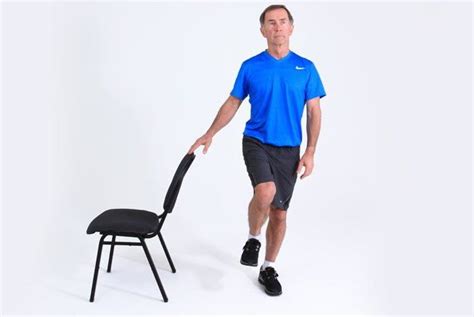 Persona mayor realizando ejercicios de equilibrio con apoyo de una silla
