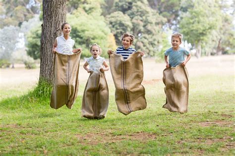 niños corriendo en una carrera de sacos al aire libre
